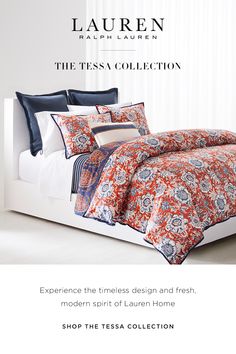 a bed with an orange, blue and white comforter on it's side