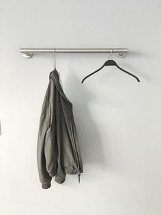 a coat hanger and two coats hanging on a wall