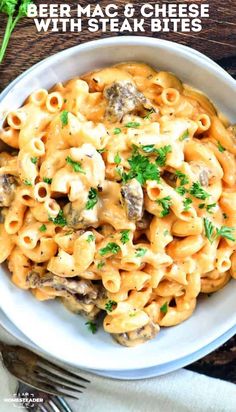 a white bowl filled with pasta covered in cheese and mushrooms, on top of a wooden table