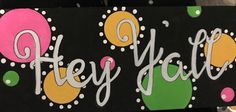 a sign that says hey hello with balloons and dots on it's black background