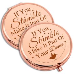 two pink compact mirrors with the words if you stumble, make it part of your dance