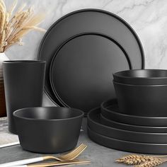 black dinnerware set with wheat stalks in the background