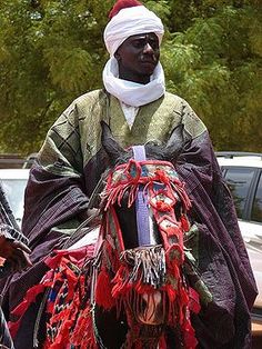 a man dressed in traditional garb and headdress, walking down the street