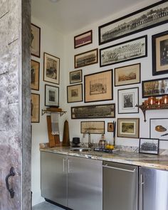 a kitchen with stainless steel appliances and pictures on the wall