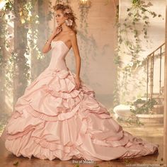 a woman in a pink wedding dress posing for the camera