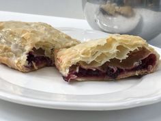 a white plate topped with a pastry cut in half