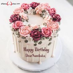 a birthday cake decorated with pink and red flowers