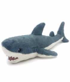 a stuffed shark is laying down on the white floor with it's mouth open