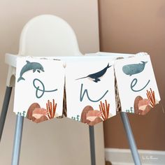 two signs with animals on them sitting next to each other in front of a chair