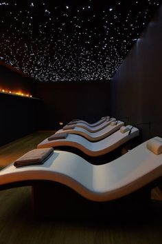 a row of white benches sitting next to each other on top of a wooden floor