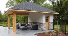 an outdoor living area with couches and a fire pit in the middle of it