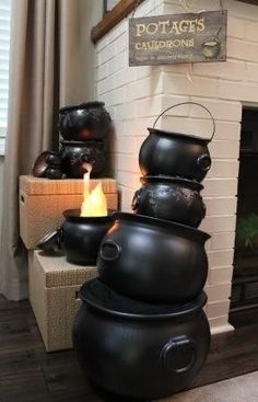 two black pots are stacked on top of each other in front of a fireplace