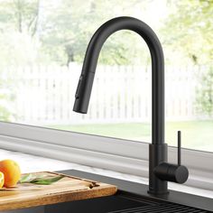 a black kitchen faucet next to a cutting board with fruit on the counter