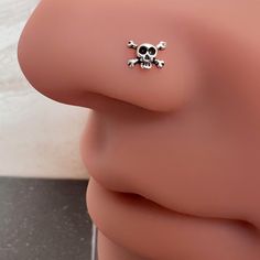 a pair of skull and crossbone earrings on top of a mannequin's head