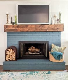 a fireplace with logs and a television above it