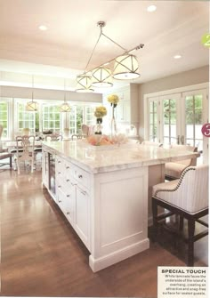 a large kitchen with an island in the middle and chairs around it on the side