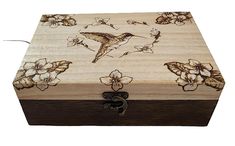 a wooden box with flowers and birds on it's lid, sitting on a white surface