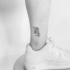 a small flower tattoo on the ankle