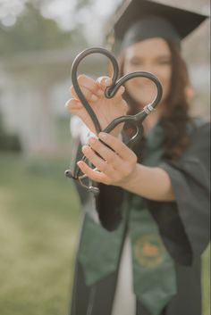 a woman in graduation cap and gown holding up a pair of scissors