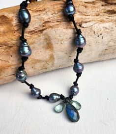 A captivating, knotted peacock pearl necklace with shimmering blue labradorite and green quartz stones hang in front. Peacock Pearls, Black Leather Necklace, Peacock Pearl, Green Quartz, California Style, Blue Labradorite