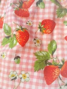 a pink and white checkered fabric with strawberries on it