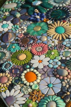 a close up view of a mosaic table top with many different colors and shapes on it