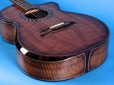 a close up of an acoustic guitar on a blue background