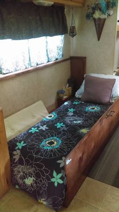 a bed sitting in the middle of a bedroom next to a window with curtains on it