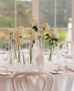 there are many vases with flowers in them on the table at this wedding reception