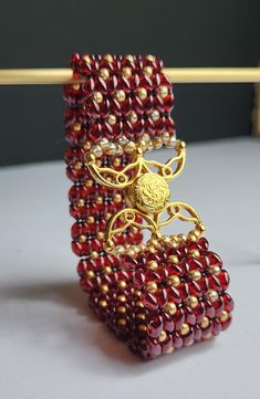 Gold lustered rich Siam ruby Superduo Czech glass beads are combined with gold Miyuki glass seed beads and a intricately beautiful Volkas III 24k gold plated magnetic clasp to create this stunning piece. The colours and design of this bracelet scream old world decadence and will definitely be make a glamourous addition to any outfit.  Dimension: 175mm x 26mm To keep your item in the best condition possible, we recommend avoiding exposure to water, harsh chemicals or perfume. To keep clean, gently wipe with a soft cloth and store either in provided box or a cool, dry location. To clean clasp or metallic accents, use included tarnish cloth.   Photographs have been minimally altered to genuinely reflect accurate item colouring. However, each devices screen may reflect colours slightly differe Super Duo, Gold Armband, Ruby Beads, Beaded Jewellery, Handmade Beaded Jewelry, Magnetic Clasp, Metallic Accents, Czech Glass Beads, Czech Glass