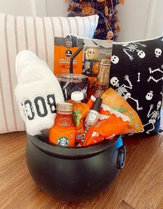 a halloween gift basket is sitting on a table next to a pillow and stuffed animal