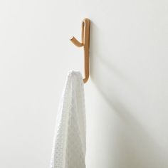 a towel hanging on the wall next to a coat rack with a wooden hook in it