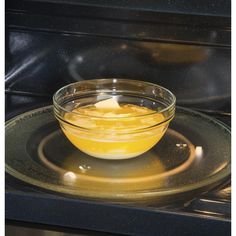 an orange is in a glass bowl on the oven burner, ready to be cooked