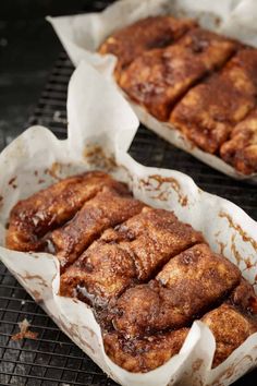 cinnamon rolls sitting on top of a cooling rack next to each other in paper wrappers