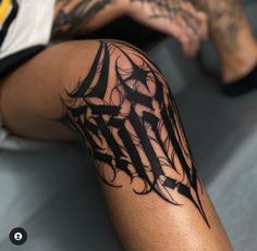 a person with a tattoo on their arm and leg is sitting in front of the camera