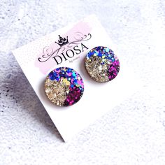 Add a pop of colour with these stunning statement studs. This style has a smooth shiny finish. All our studs are designed and handmade in Australia. These vibrant colours and glitter combinations are a perfect accessory with any day-time or evening outfit.  The resin, pigment and glitter are carefully selected and mixed to create a stunning unique product. Every pair is individually made by Mimi. Note that your pair of studs may be slightly different to those in the photographs.  2.5 cm diameter Iridescent Glitter Earrings As Gift, Glitter Round Earrings For Gifts, Purple Glitter Earrings For Gift, Resin Pigment, Earrings Circle, Rose Violette, Evening Outfit, Pink Purple Blue, Round Stud Earrings