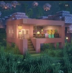 a small pink house in the middle of some bushes and trees with lights on it