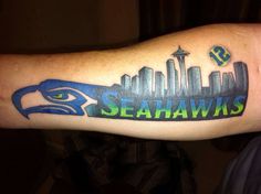 the seattle skyline is shown with an eagle on it's arm, which reads seahawks