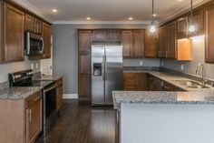 a kitchen with wooden cabinets and granite counter tops