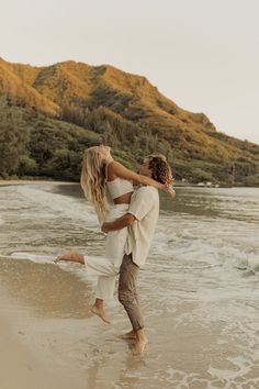 a man and woman are hugging on the beach