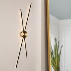 a clock that is on the wall next to a potted plant in a room