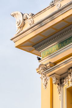 a clock on the side of a yellow building