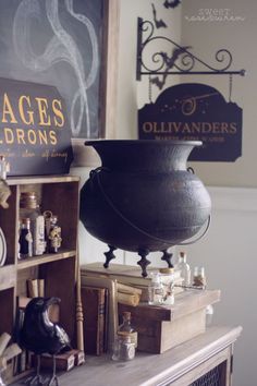 there is a large black vase on top of a shelf next to other antique items