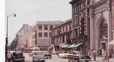 an old photo of cars driving down the street