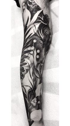 black and white photo of a woman's leg with flowers on it, done by the artist