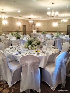 the banquet room is set up with white linens and flowers