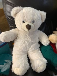 a white teddy bear sitting on top of an office chair