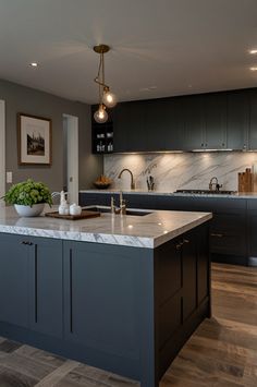 a large kitchen with an island in the middle and marble counter tops on both sides