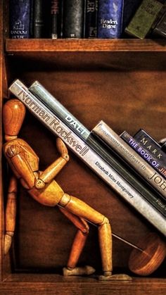 a painting of a wooden man holding two books in front of a book shelf filled with books