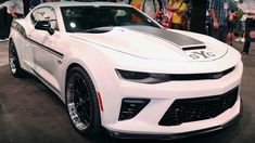 a white chevrolet camaro is on display at an auto show